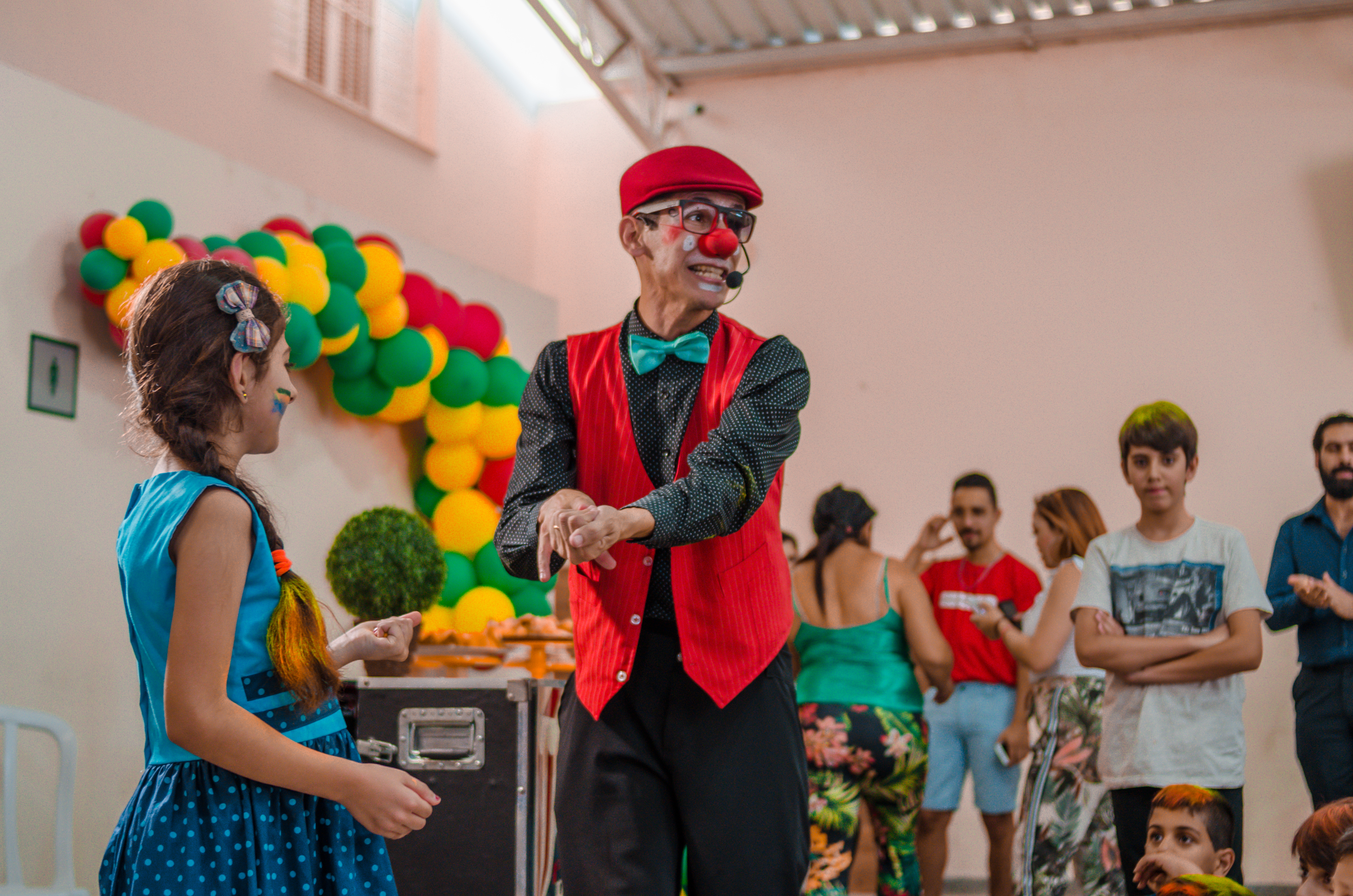 Criança em atividade recreativa com palhaço em evento comunitário do projeto