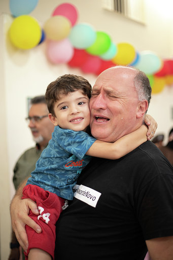 Abraço emocionado entre adulto e criança em evento do Experimente Nascer de Novo